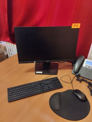 un bureau sur lequel se trouvent un ordinateur, un clavier, une souris et un téléphone