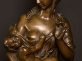 a bronze statue of a woman holding a baby in her arms