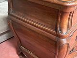 a wooden chest of drawers in a room with a couch