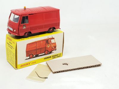 un petit camion rouge posé sur une boîte en carton