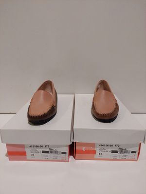 une paire de chaussures pour femme dans une boîte posée sur une surface blanche