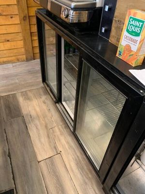 un parquet en bois massif dans une cuisine équipée d'un réfrigérateur et d'un plan de travail