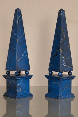 pair of blue marble obelisks on a table with a white background