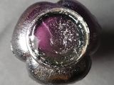 a close up of a purple glass object on a table