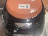 an orange and black rice cooker on display in a glass case
