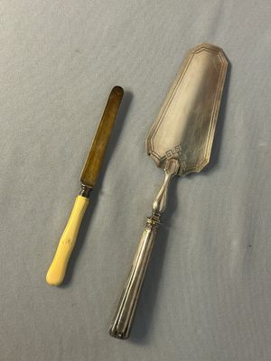 a silver spoon and a yellow handled knife on a table