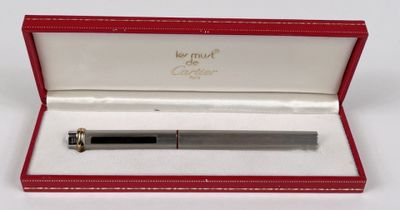 un stylo argenté dans une boîte rouge posée sur une surface blanche