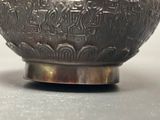 a silver bowl with a design on it on a table