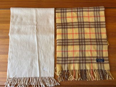 two scarves on a wooden table with a brown and yellow plaid
