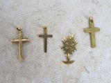 three gold crosses and a cross pendant on a marble surface