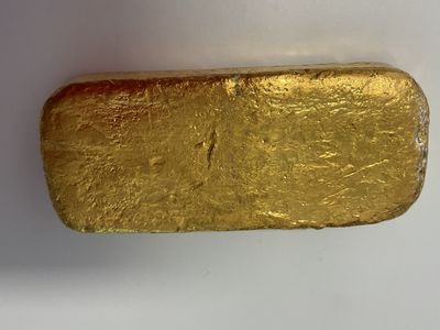 un gros plan d'un morceau d'or sur une surface blanche
