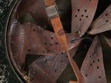 an old military helmet with a leather strap on a black surface