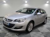 L'Opel argentée est garée dans une pièce au sol carrelé en damier.