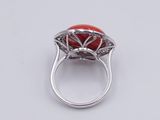a close up of a ring with a red stone in it