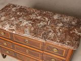 a marble top chest of drawers on display in a room
