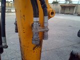 a close up view of a yellow excavator with two hoses attached to it