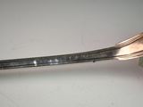 a silver spoon and a fork on a white table