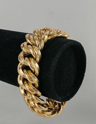 a close up of a gold bracelet on a black ring