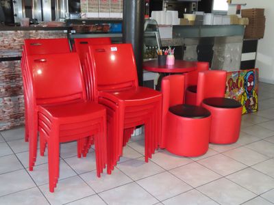 quatre chaises rouges et une table dans un restaurant