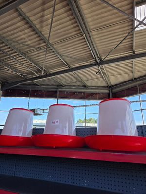 several red and white buckets are lined up on a shelf