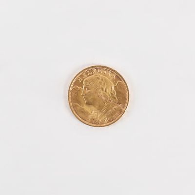 gros plan d'une pièce d'or sur une surface blanche