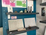 a blue wall with a shelf with various items on it