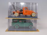two toy trucks in a clear case on a shelf
