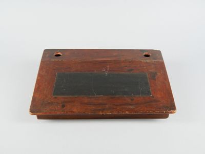 une vieille plaque en bois sur laquelle est fixée une ardoise noire