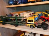de nombreux camions miniatures posés sur une étagère dans une pièce