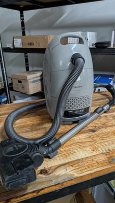 un aspirateur posé sur une table en bois