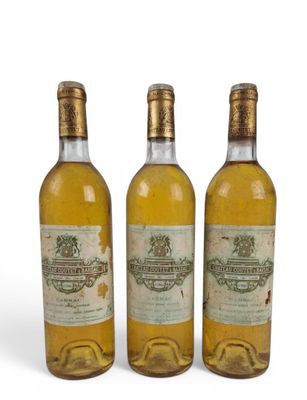 trois bouteilles de vin posées les unes à côté des autres sur une surface blanche