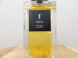 the bottle of gold perfume is sitting on a wooden table