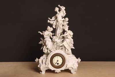 une horloge blanche ornée d'anges, posée sur une table