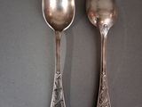 two spoons that are sitting side by side on a table