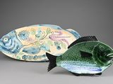 deux figurines décoratives représentant des poissons, placées l'une à côté de l'autre