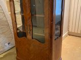 a wooden cabinet with a glass door in a room