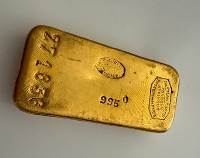 a close up of a gold bar on a white surface