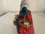 figurine of a woman with a basket of vegetables on a table
