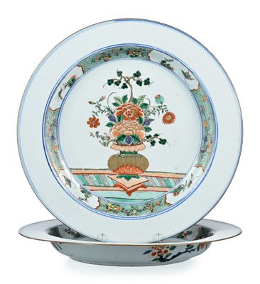 une assiette sur laquelle est disposée une composition florale, posée sur un support à assiette