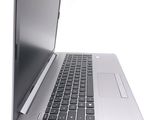 a silver laptop with a black keyboard on a white surface