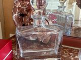 a glass bottle sitting on a table next to a mirror