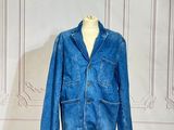 une veste en jean posée sur un mannequin devant un mur blanc