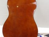 an acoustic guitar sitting on top of a table next to a book