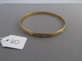 un bracelet en or avec une étiquette de prix posé sur une table