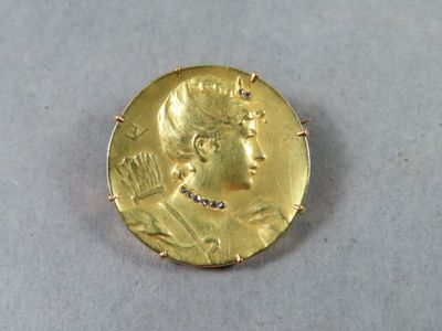 gros plan d'une pièce d'or portant un visage de femme