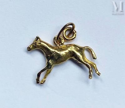 a close up of a gold horse charm on a white surface