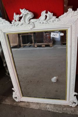 un miroir posé par terre devant un mur rouge