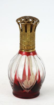 un vase en verre rouge et blanc surmonté d'une couronne dorée