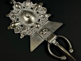 une petite broche en argent ornée d'un oiseau et d'une paire de ciseaux au milieu