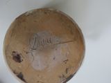 a brown vase with writing on it sitting on a table